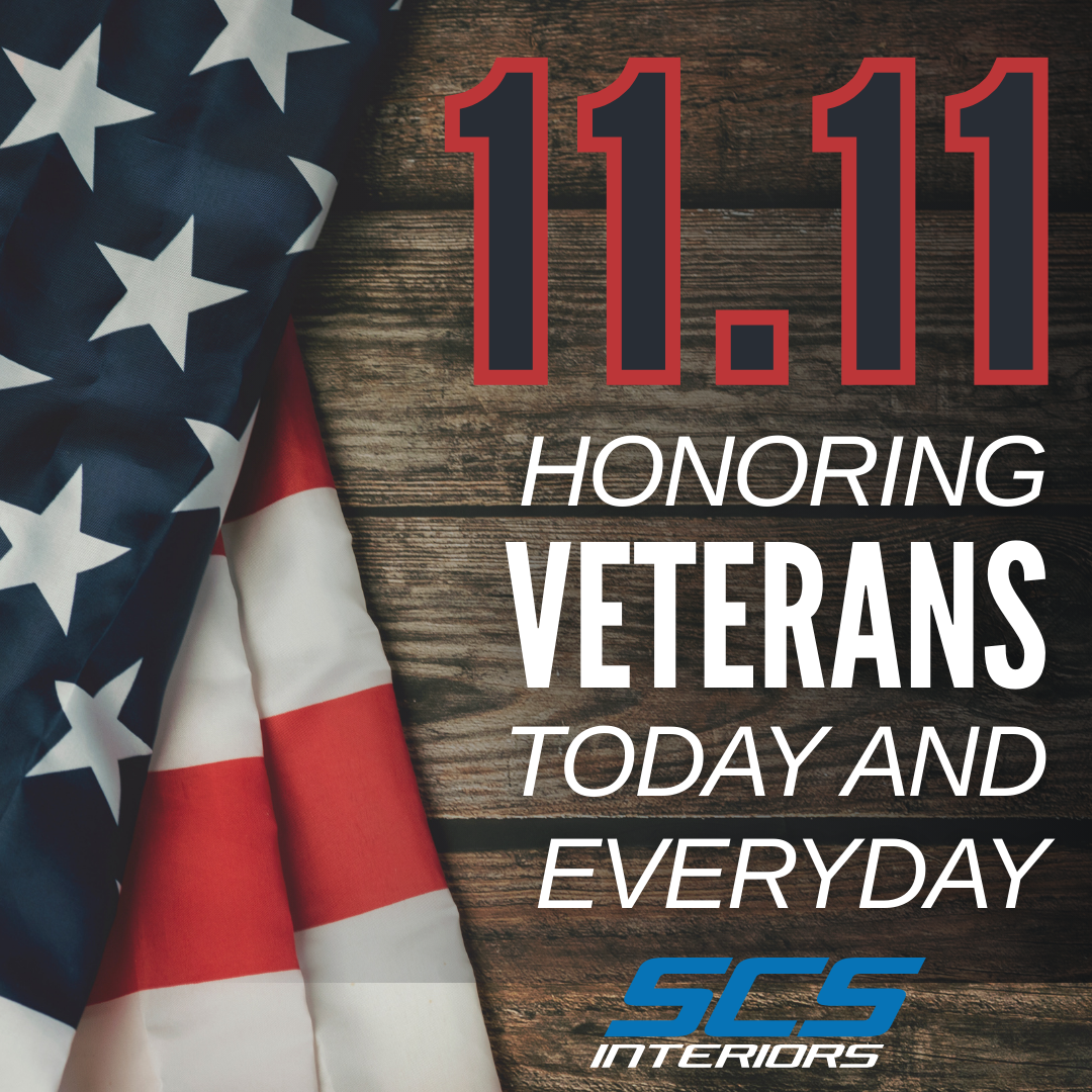 11.11 Honoring Veterans Today and Everyday with SCS Logo. Brown wooden background with a flag to the left.